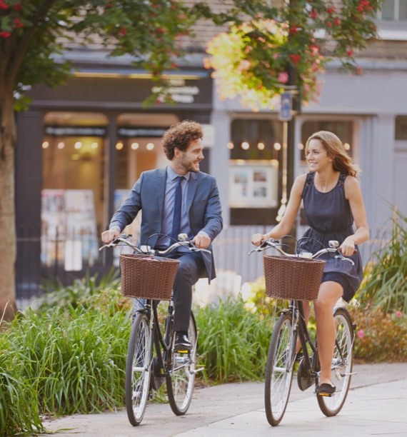 man and woman riding bikes in dress clothes